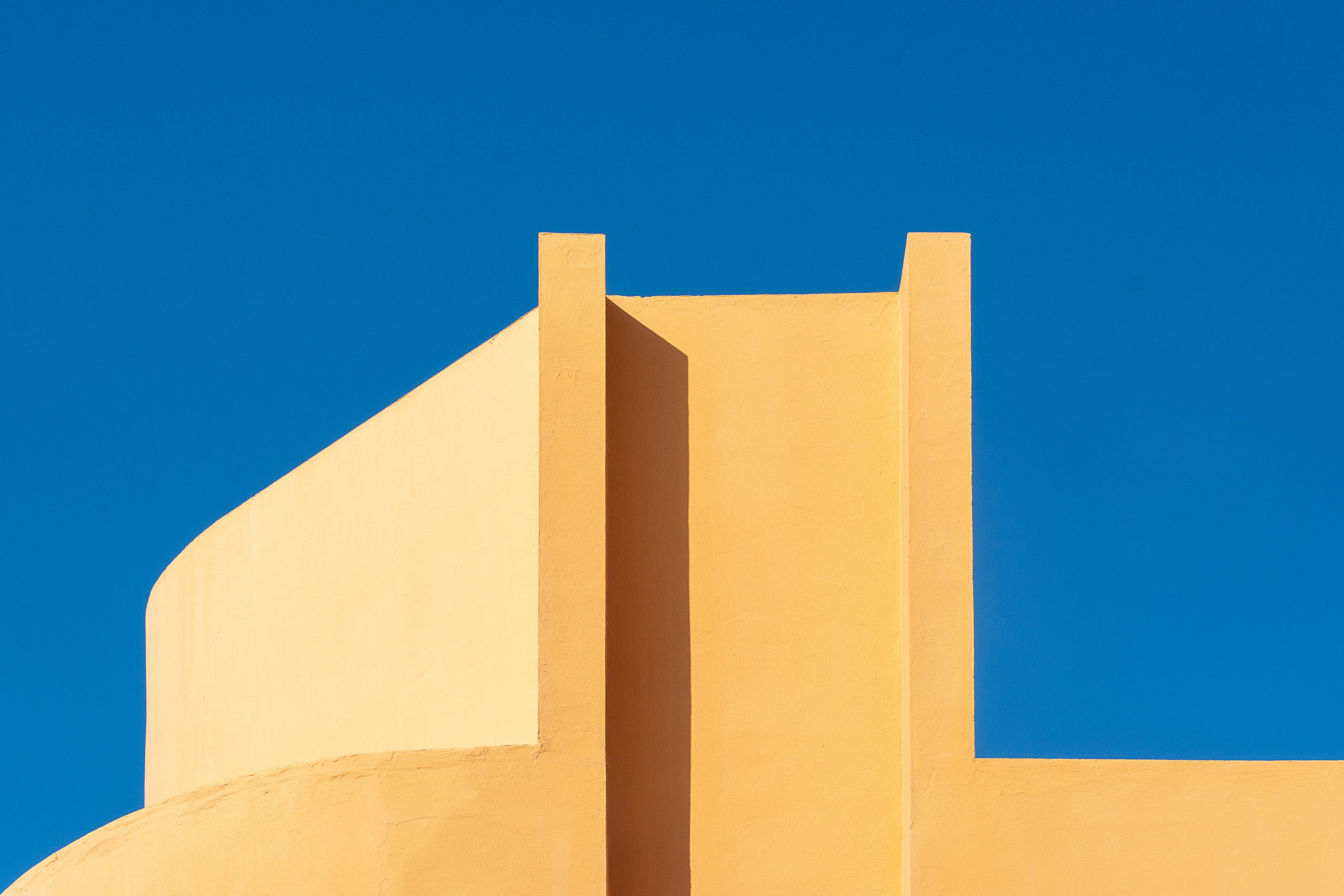 Gratis Design architettonico minimalista con netto contrasto tra il giallo e il blu catturato alla luce del giorno. Foto a disposizione