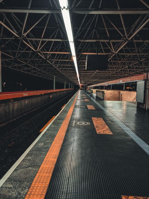 Free A deserted train platform at night highlighting industrial architecture with vivid lighting. Stock Photo