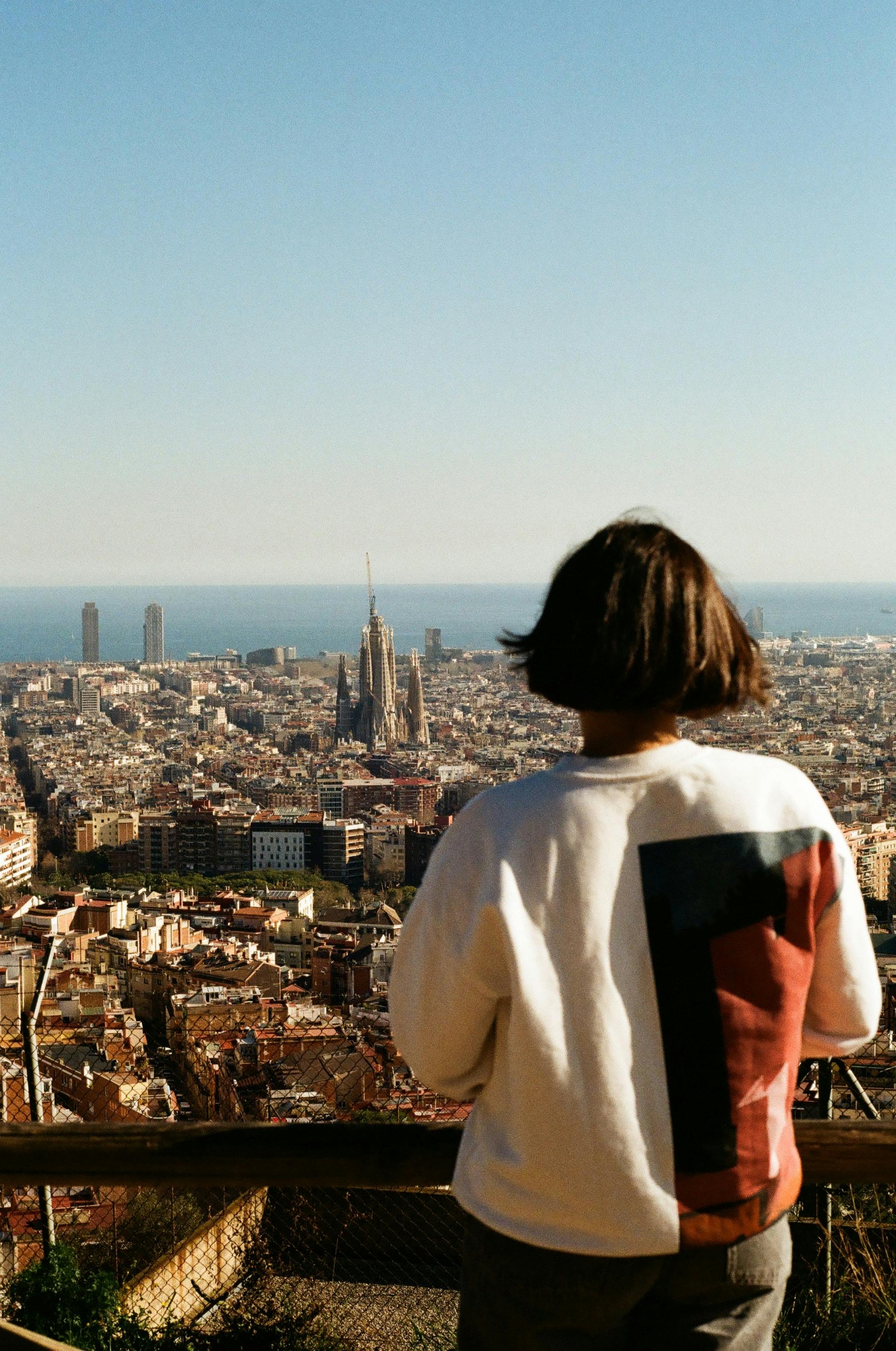 A woman observes the stunning view of Barcelona and the iconic Sagrada Familia.