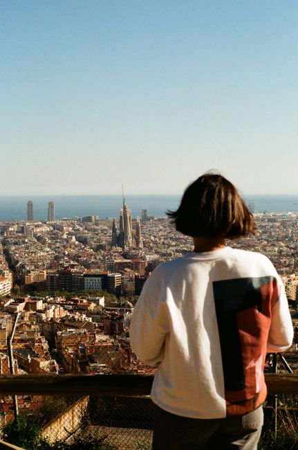 A woman observes the stunning view of Barcelona and the iconic Sagrada Familia.