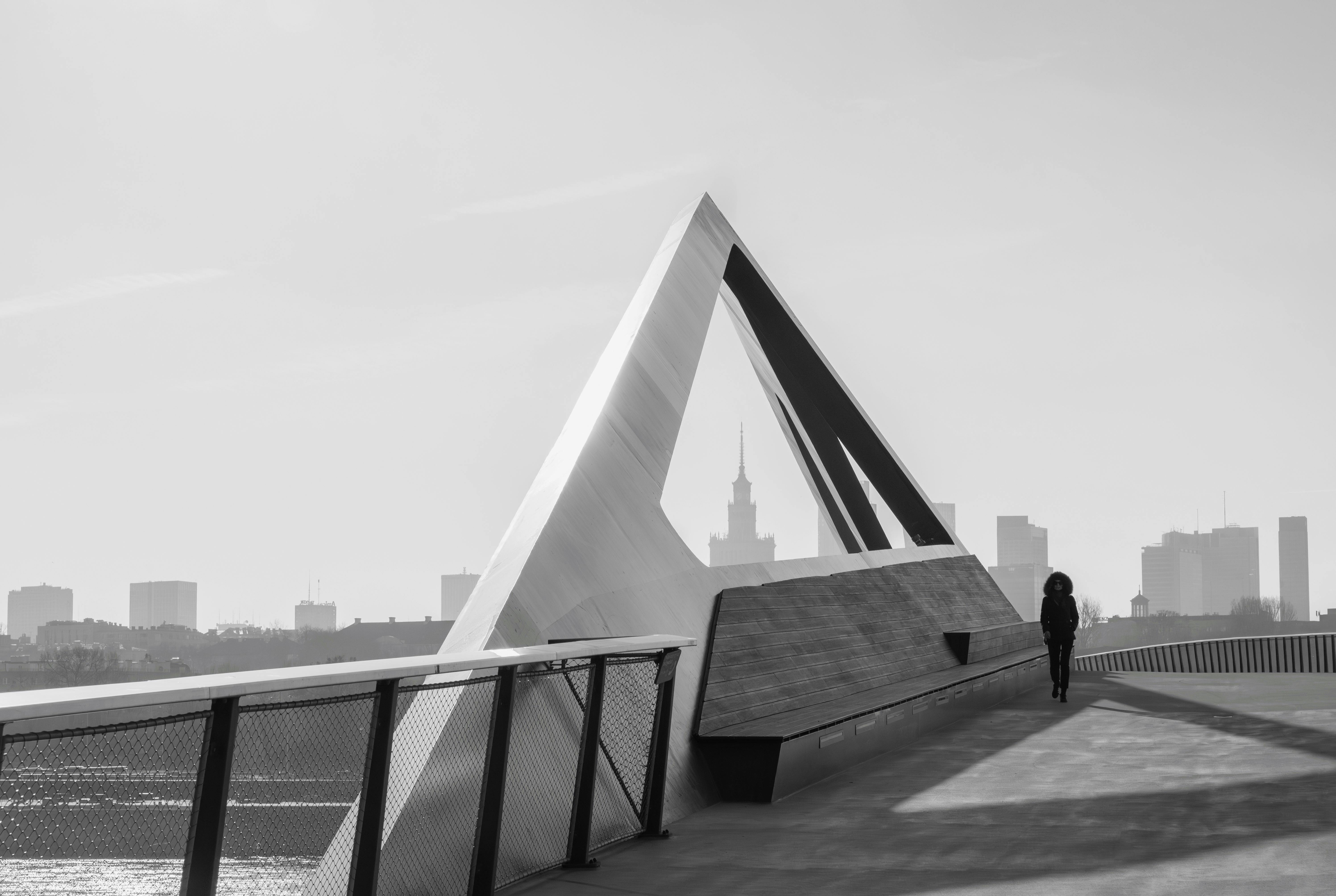 Gratis Svart-hvitt bilde av en moderne trekantet struktur med Warszawas skyline i bakgrunnen. Arkivbilde