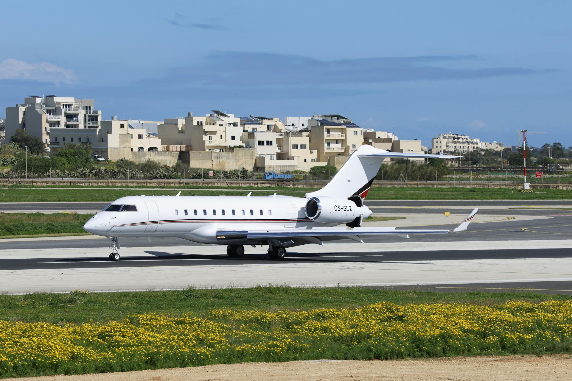 A sleek private jet preparing for takeoff on a clear day at a modern airport.