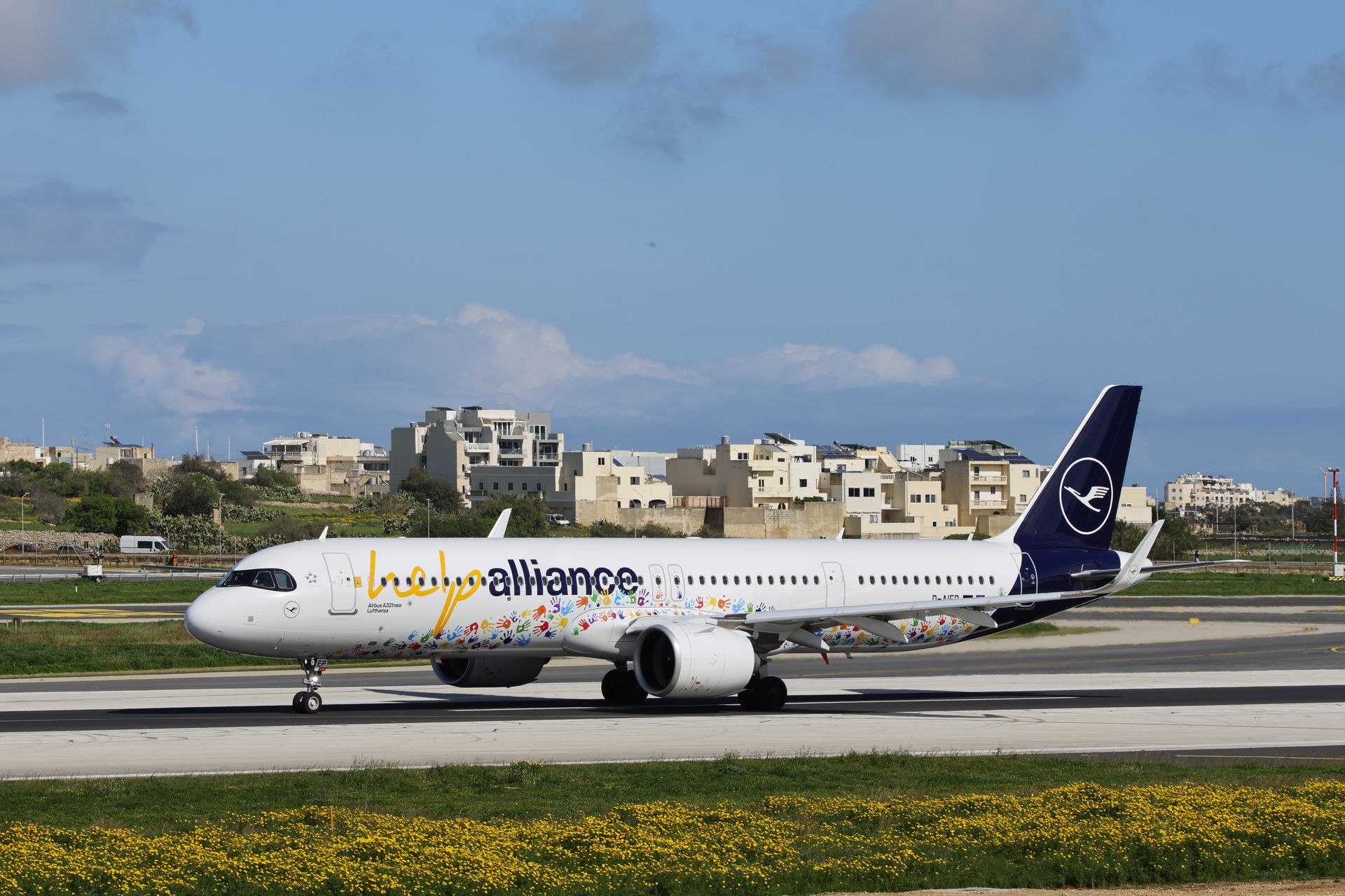 Airbus A321 featuring colorful Hello Alliance livery parked on runway.