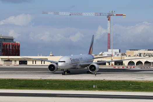 Aircraft on tarmac at airport with clear blue sky and construction crane.