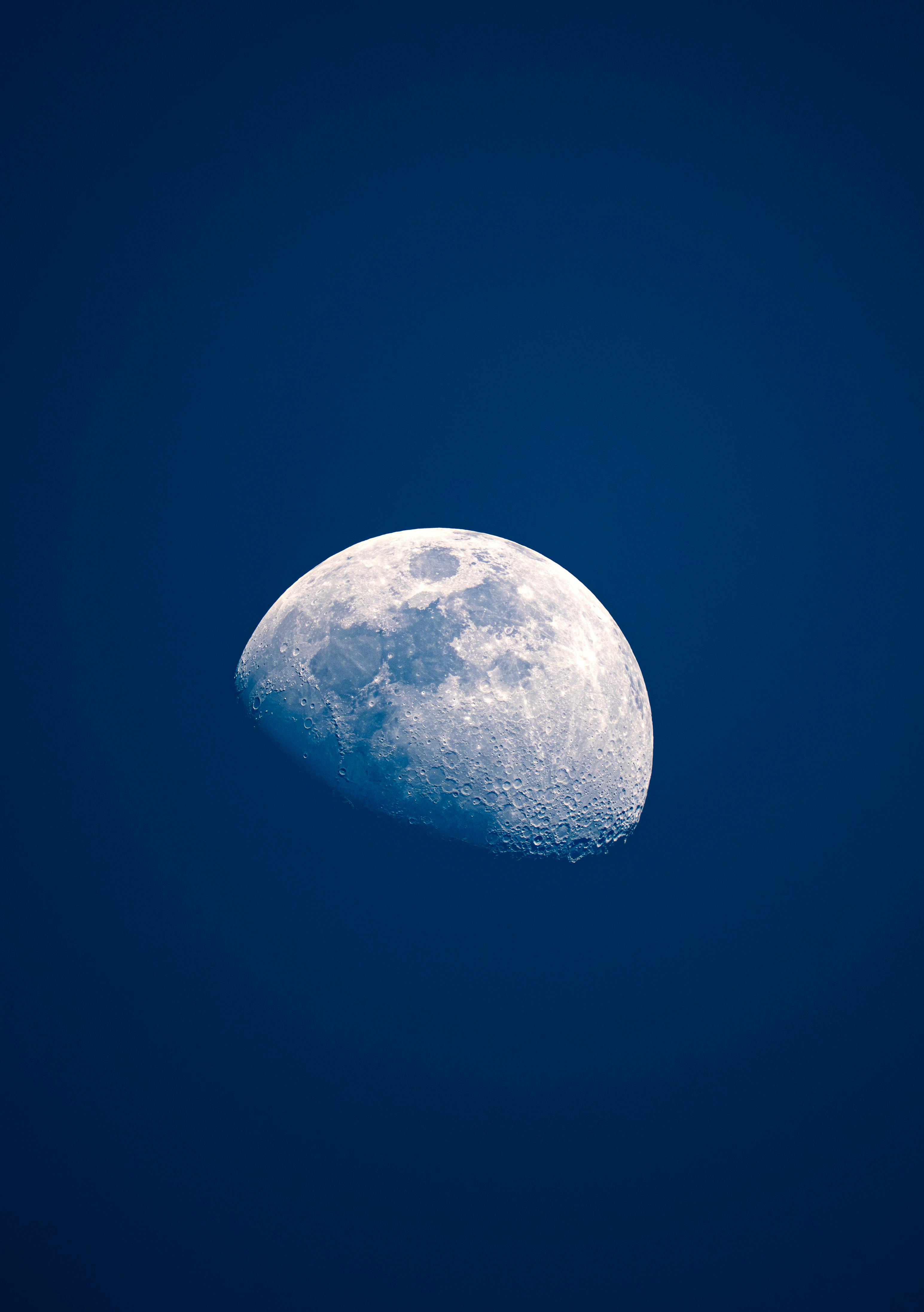 A striking image of a half moon against a deep blue night sky, captured from Yalova, Türkiye.