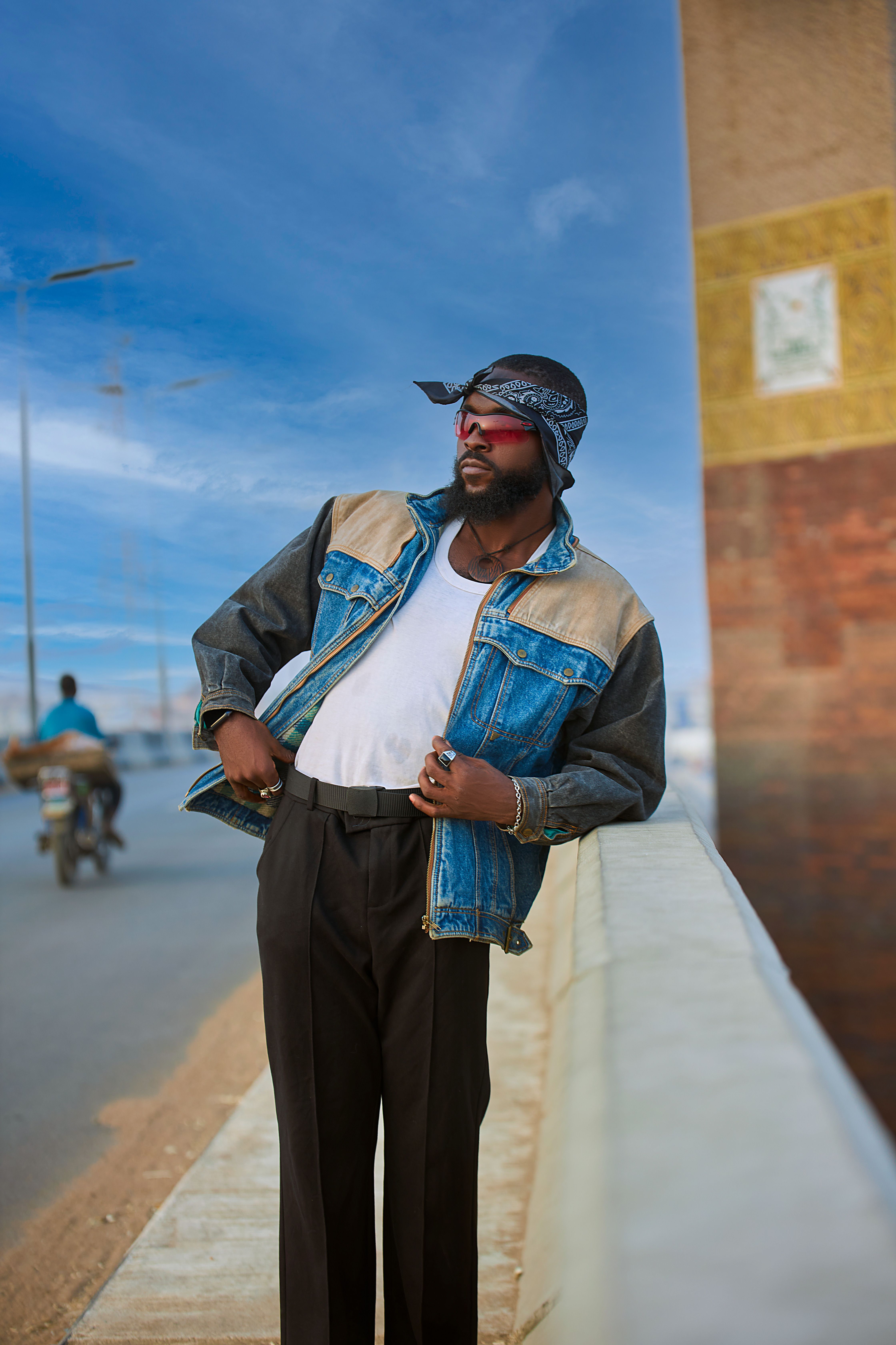 Stylish man in denim jacket leaning on urban wall · Free Stock Photo