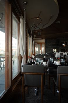 Sophisticated restaurant setting with stylish seating and natural light streaming through large windows.