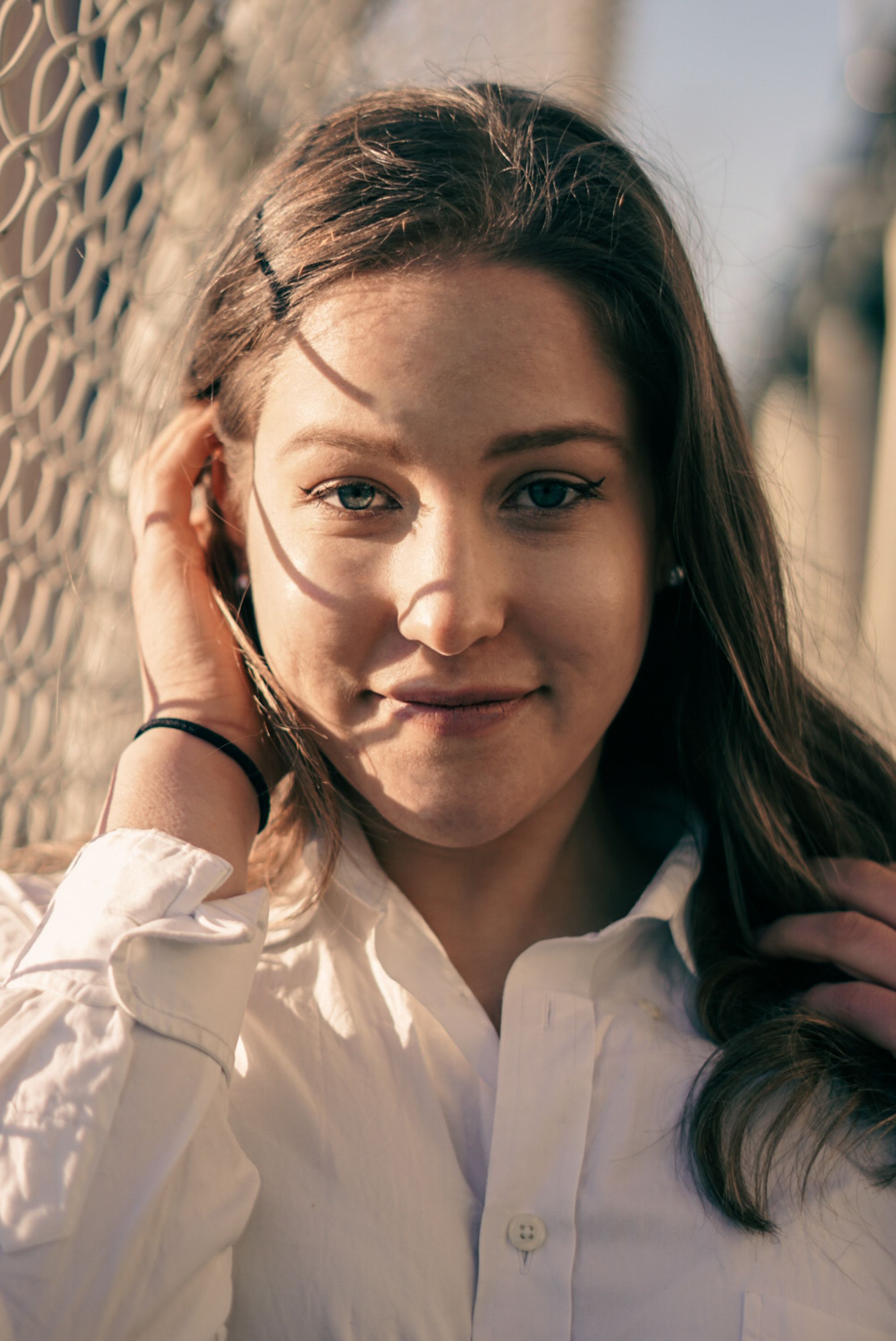 Charming young woman in a white shirt posing outdoors in New York City.