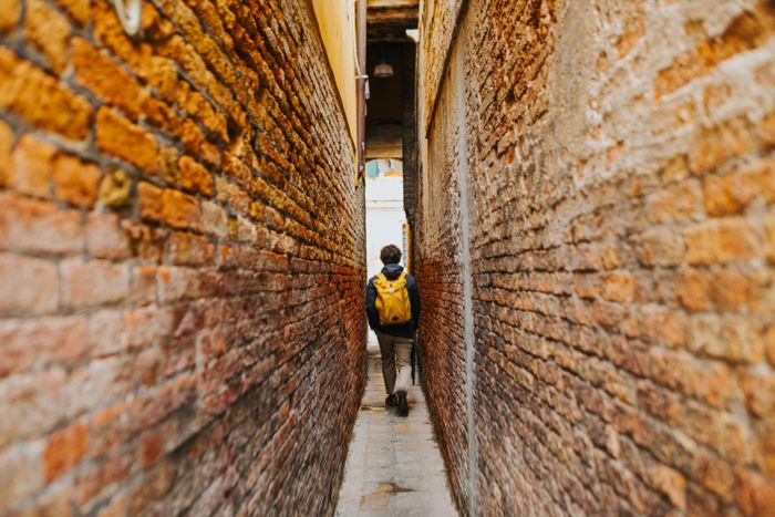 Walking a narrow brick passage — photo by Helena Jankovičová Kováčová on Pexels