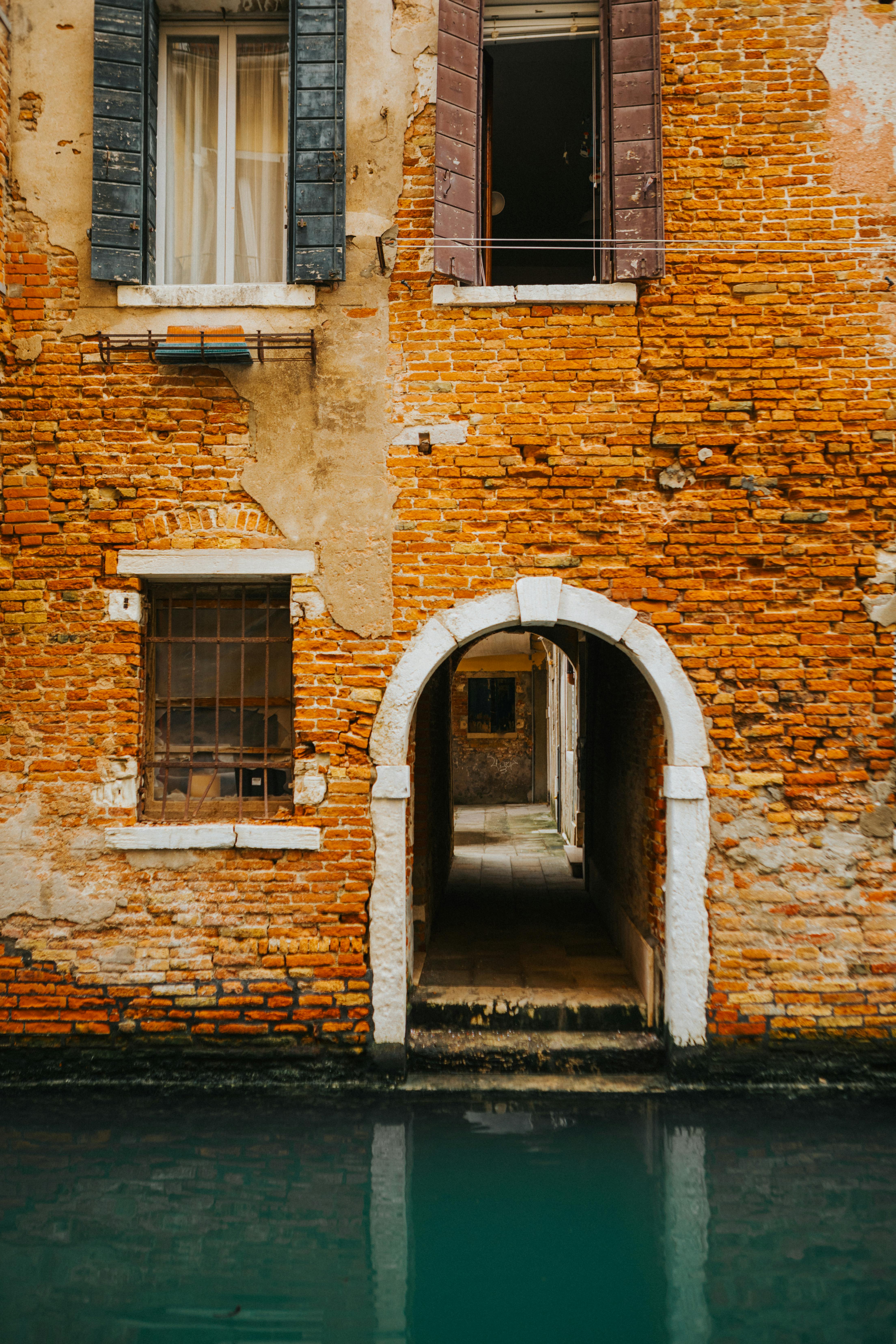 Charming brick archway entrance by a canal in Venice.