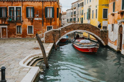 Picturesque canal scene in Venice, showcasing a historic bridge and colorful buildings.