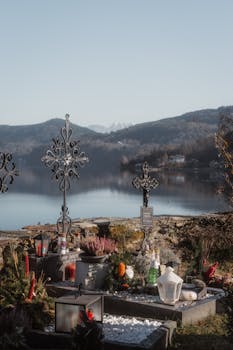 Tranquil cemetery by a serene lake with mountain backdrop, capturing sacred reflections and peaceful scenery.