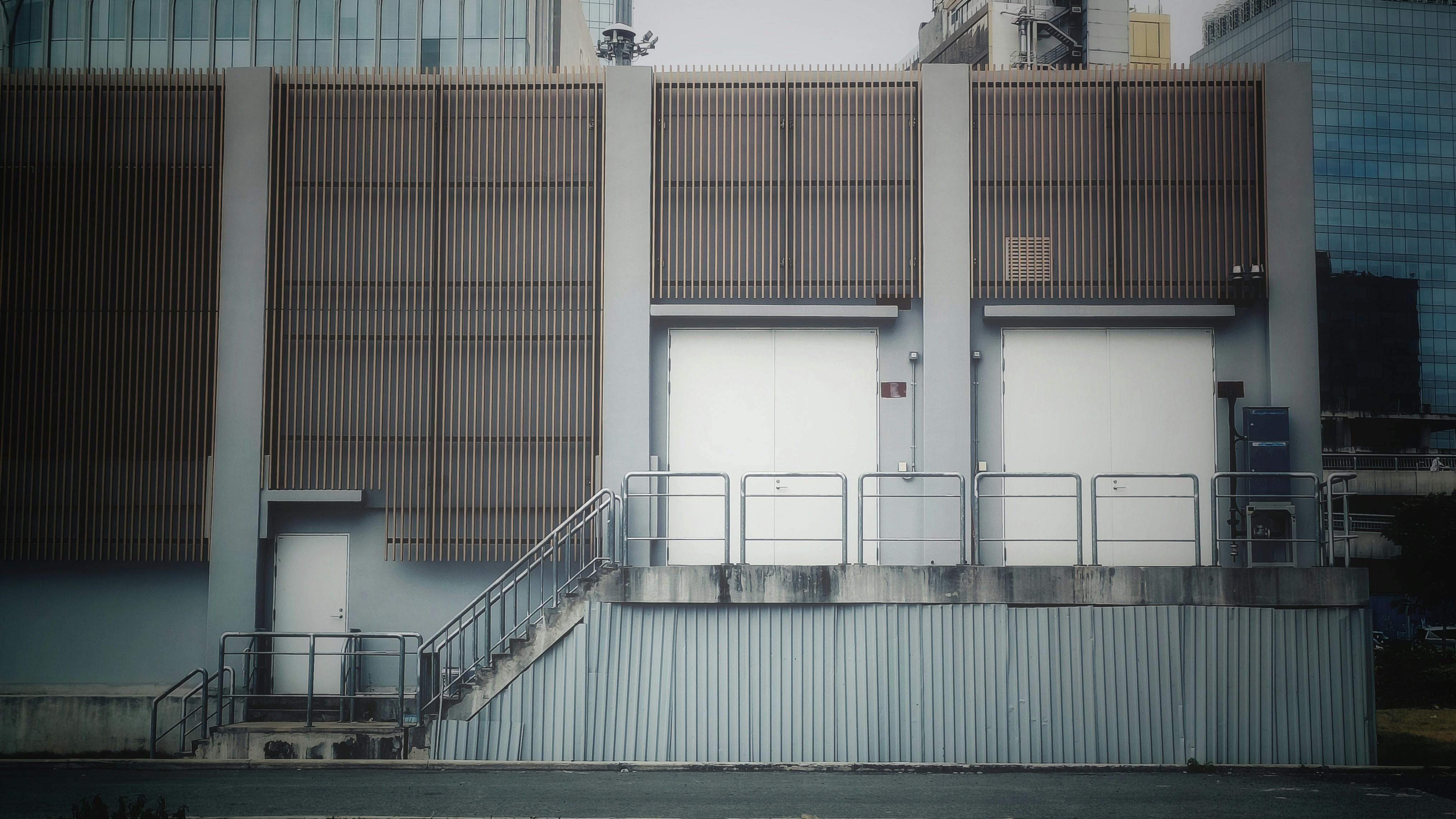 Ilmainen Moderni teollisuusrakennuksen julkisivu metalliportaat ja teksturoidut seinät. Kuvapankkikuva