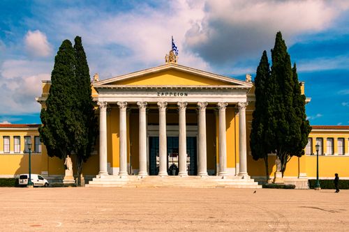 Free Historic Zappeion Megaron building in Athens with scenic sky and tree-lined walkway. Stock Photo