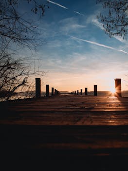 A tranquil sunrise over Wörthsee in Bavaria with an old pier and warm golden light.