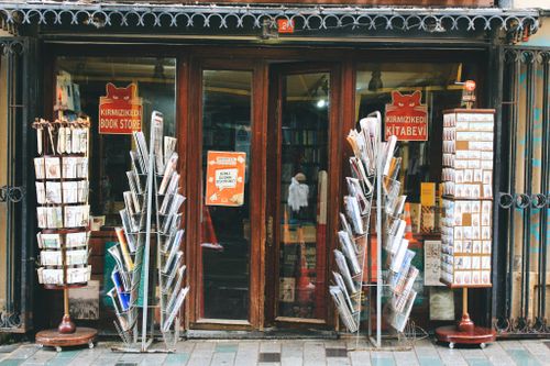Free Exterior view of Kirmizikedi bookstore with colorful magazine racks outside. Stock Photo