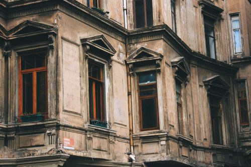 Free Close-up view of an aged building facade with wooden windows and ornate details. Stock Photo
