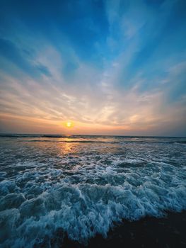Capture of a vivid beach sunset with dynamic waves and an expansive sky, perfect for backgrounds.
