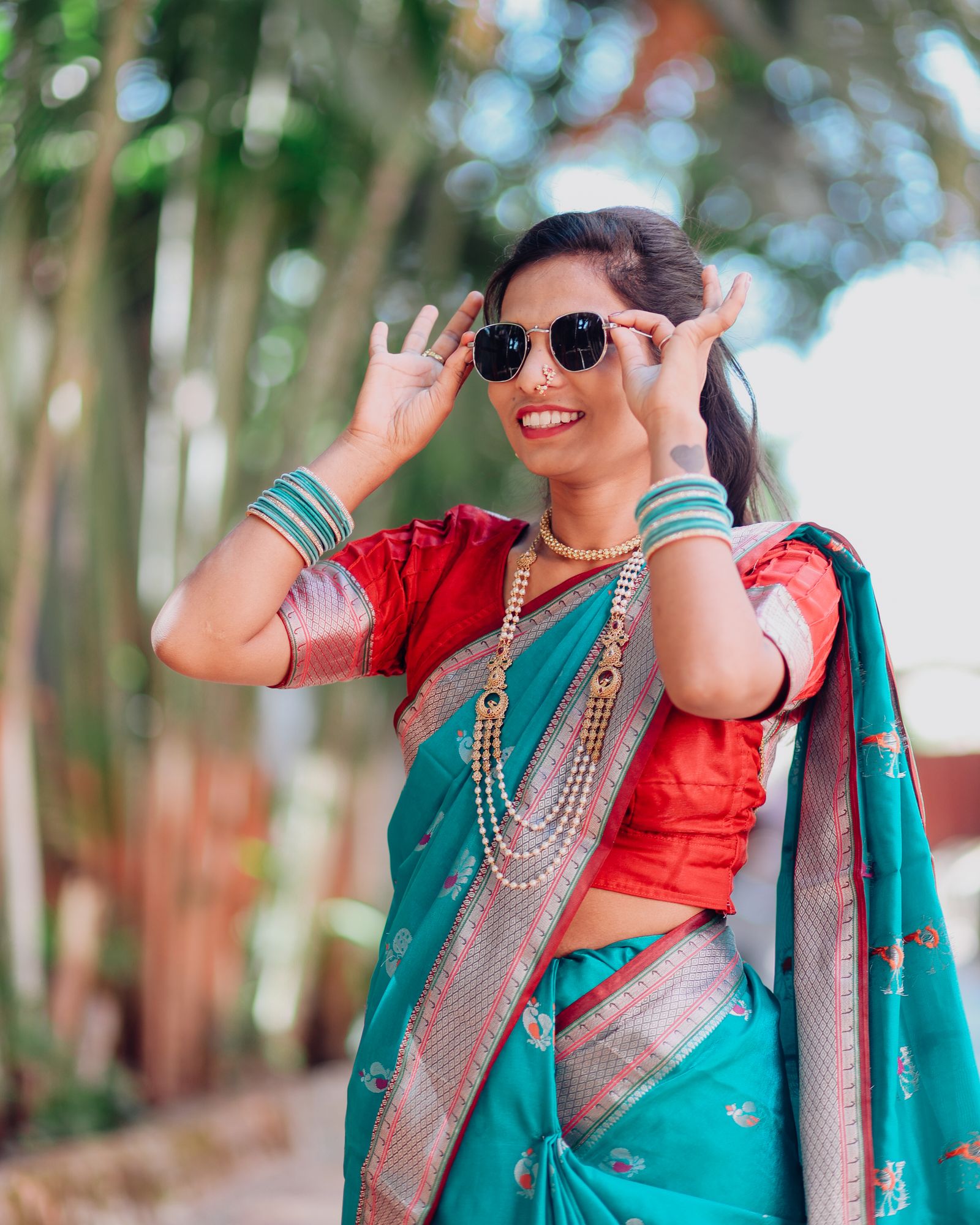Woman in a saree adjusting her sunglasses