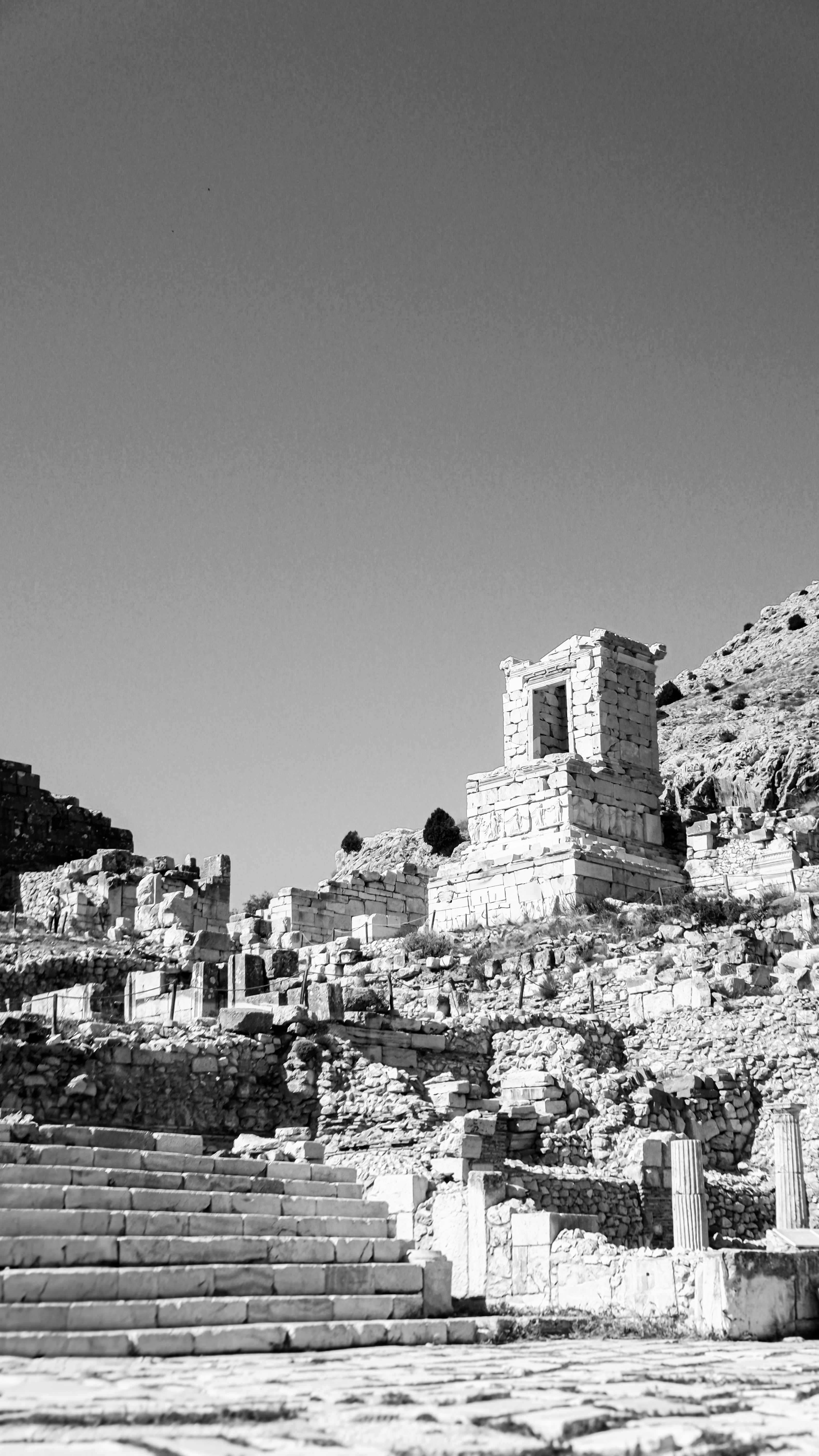 Black and white photo of ancient ruins with clear skies.