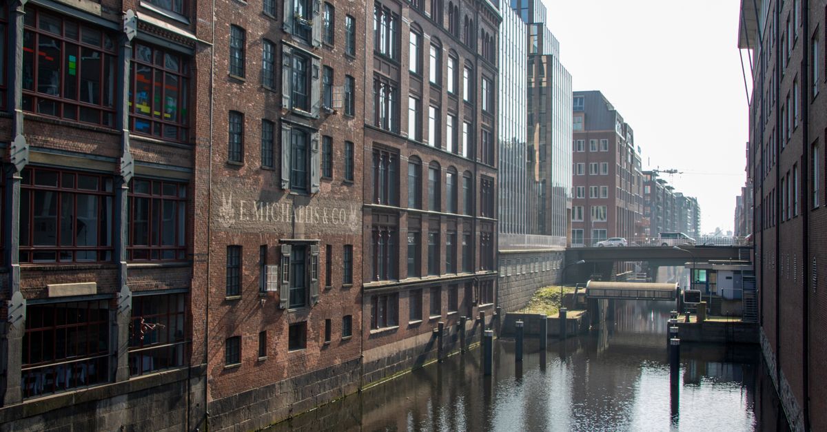 Historic brick architecture along a serene canal in Hamburg, Germany. Vibrant urban landscape.