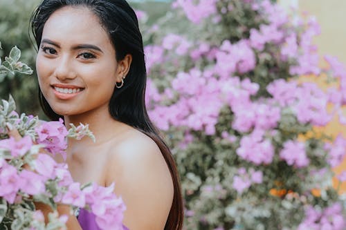 Free Woman Smiling Beside Pink Flowers Stock Photo