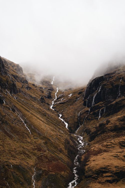 Free A tranquil scene of mist-covered mountains in Fort William, showcasing Scotland's natural beauty. Stock Photo
