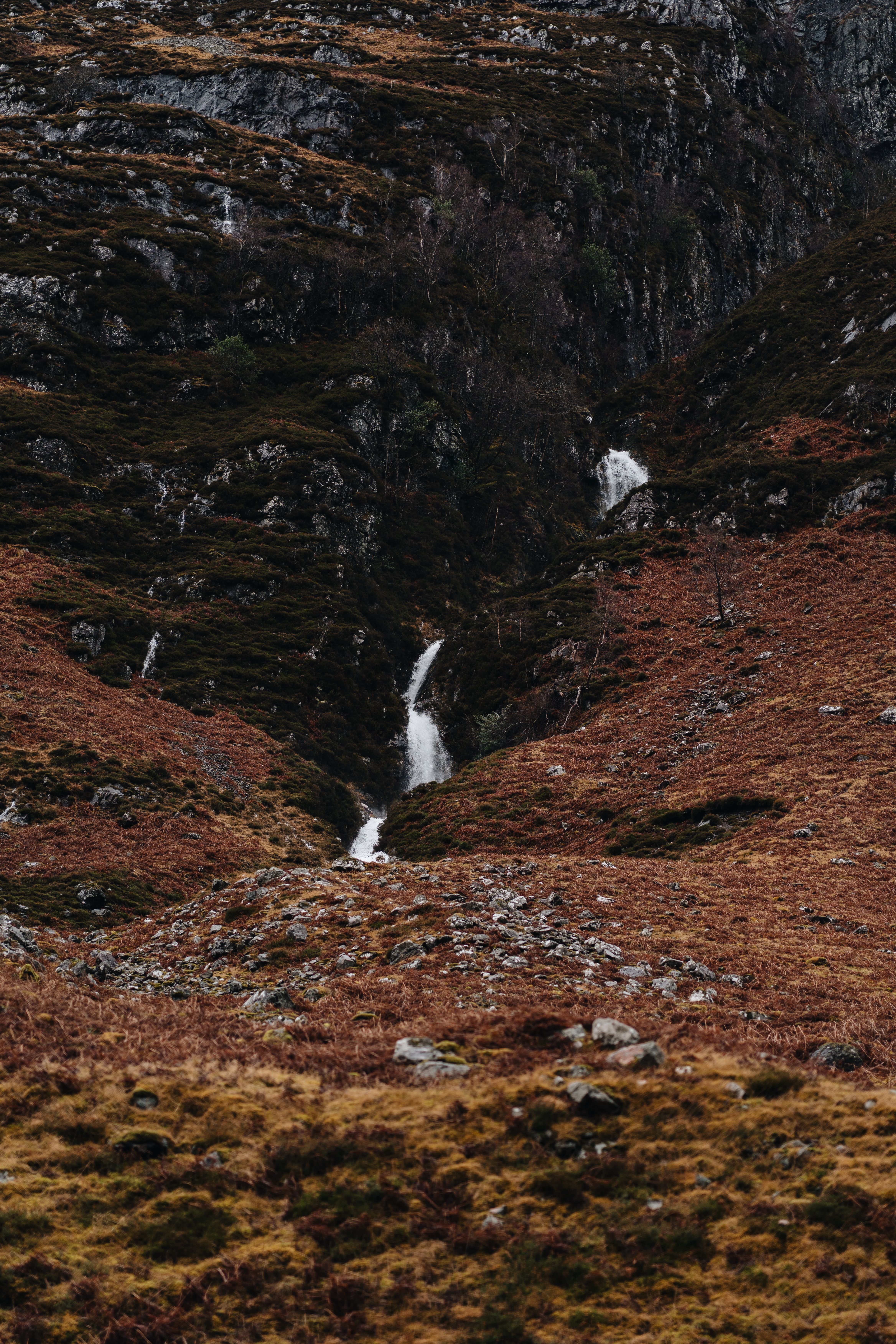 Tranquil waterfall cascading down a rocky hillside in Fort William, Scotland.