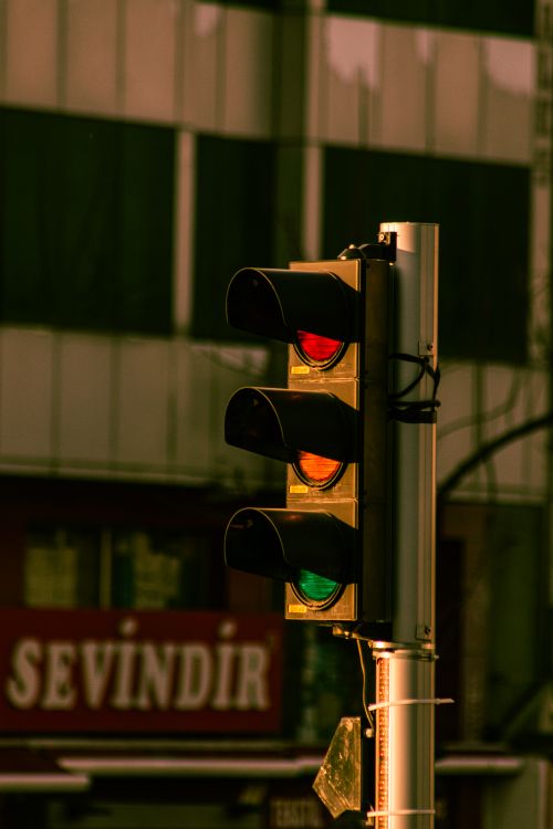 Free Urban traffic light showing a red stop signal against a blurred city background. Stock Photo
