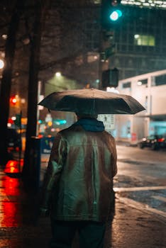 Person with umbrella on a rainy night in Seattle's urban streets.