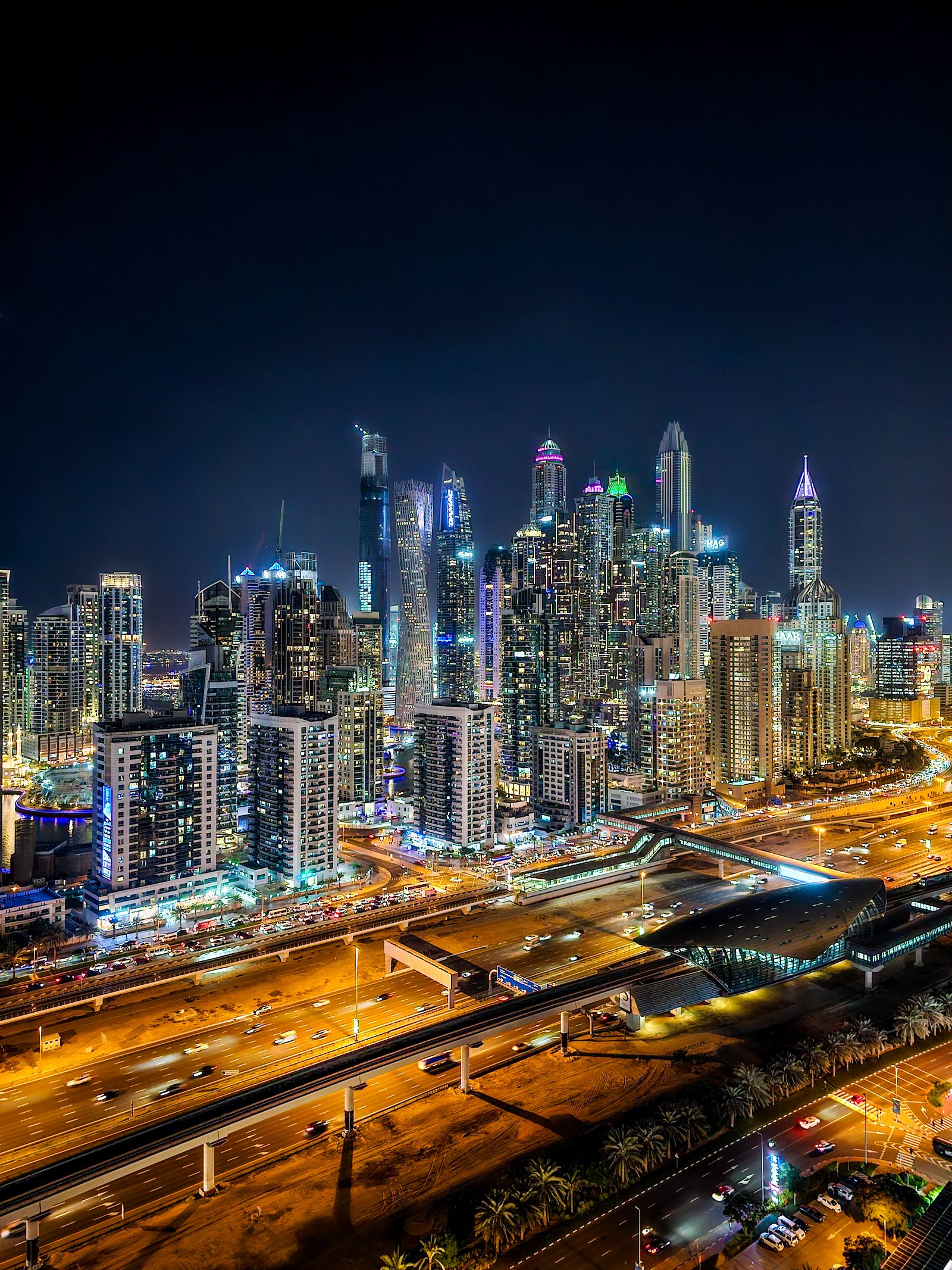 Dubai skyline at night from above - a sea of gold and neon stretching to the horizon