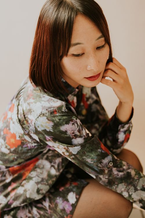 Thoughtful Woman in Floral Dress Posing Indoors · Free Stock Photo