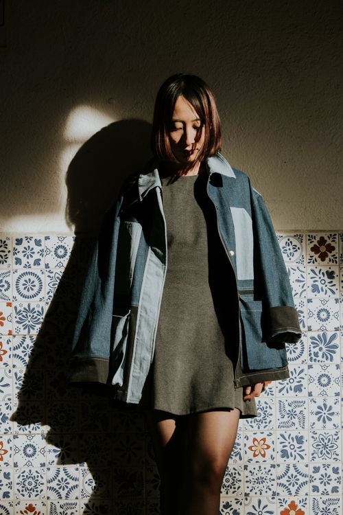 Woman in a denim jacket over a floral dress