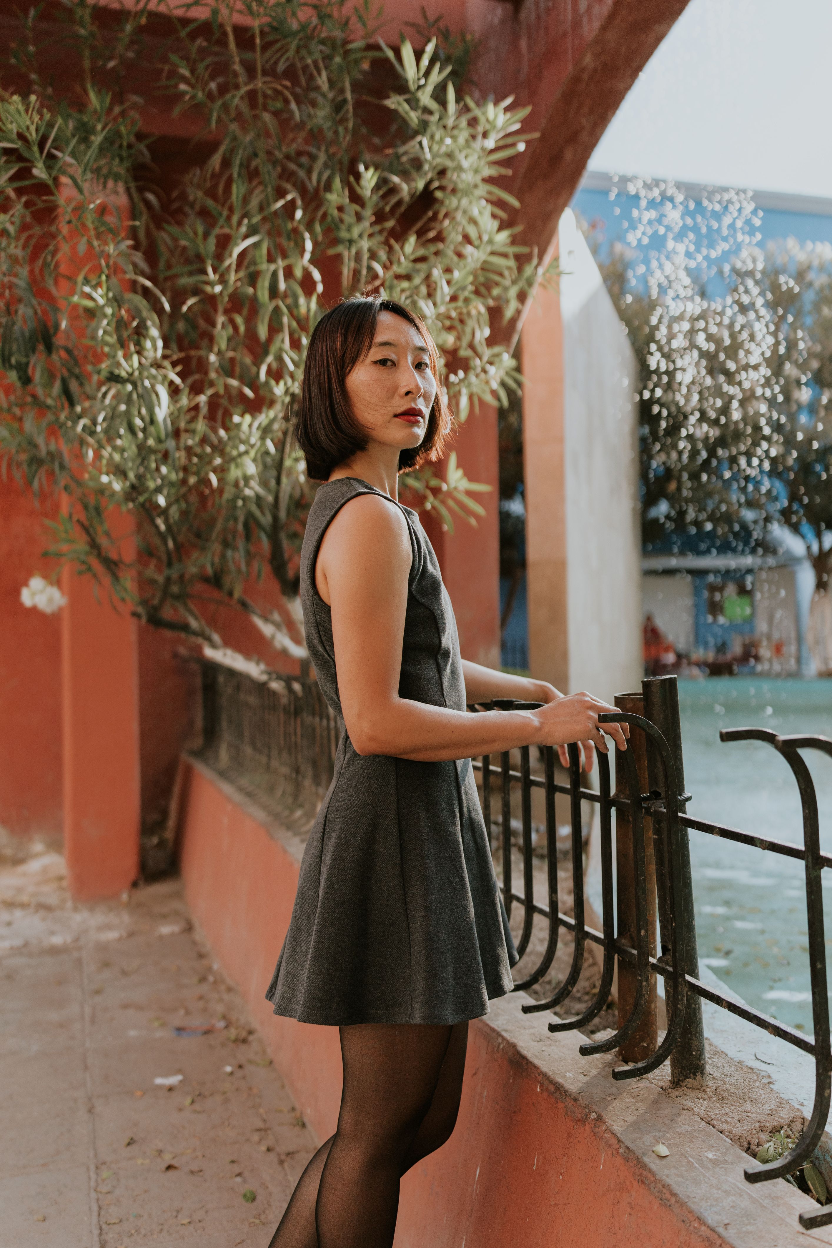 Woman in Stylish Dress by Outdoor Iron Fence  Free Stock Photo