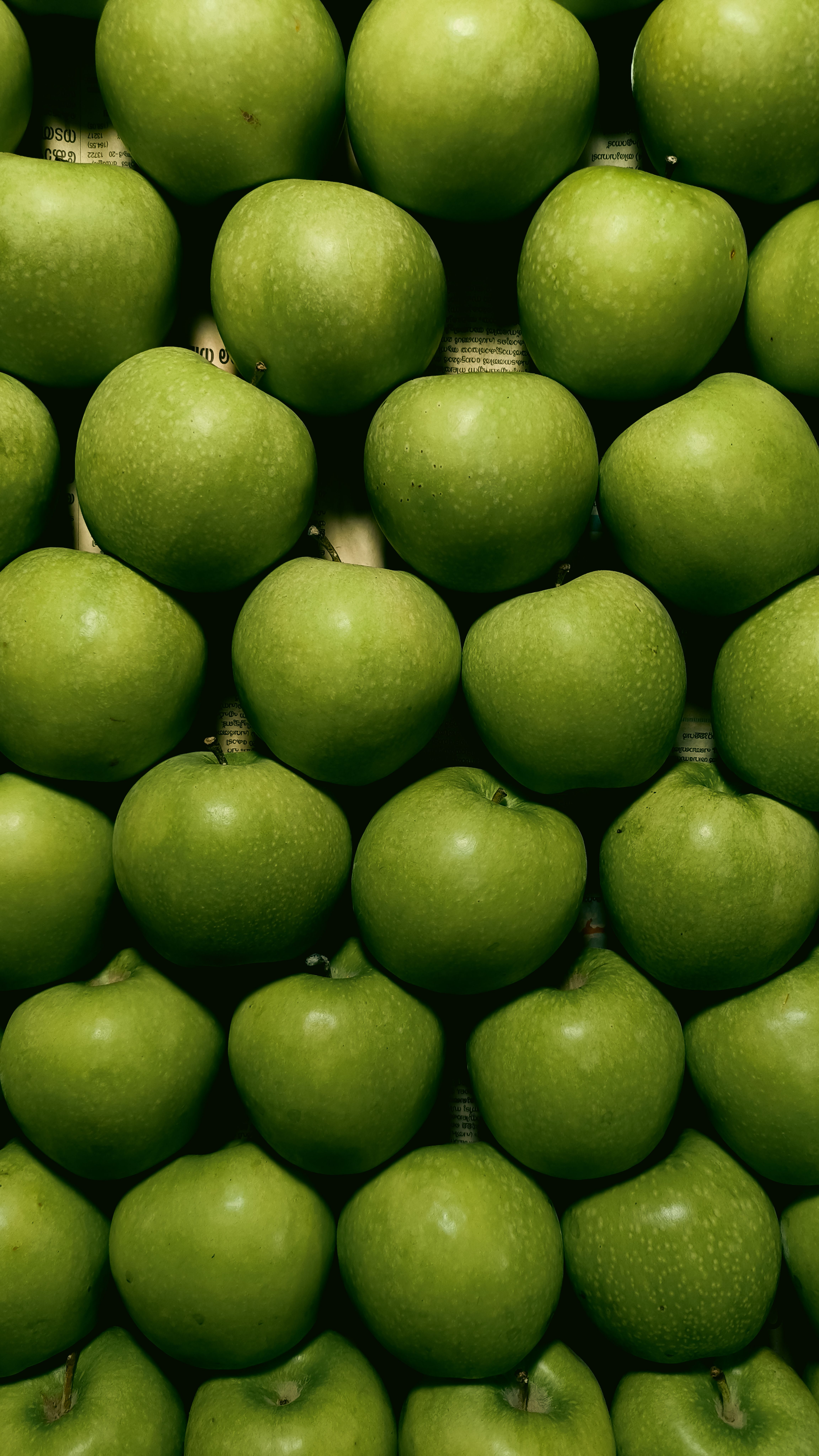 A golden-brown oat streusel topping over bubbling sliced Granny Smith apples in a white ceramic baking dish, with a scoop removed showing the tender apple filling underneath.