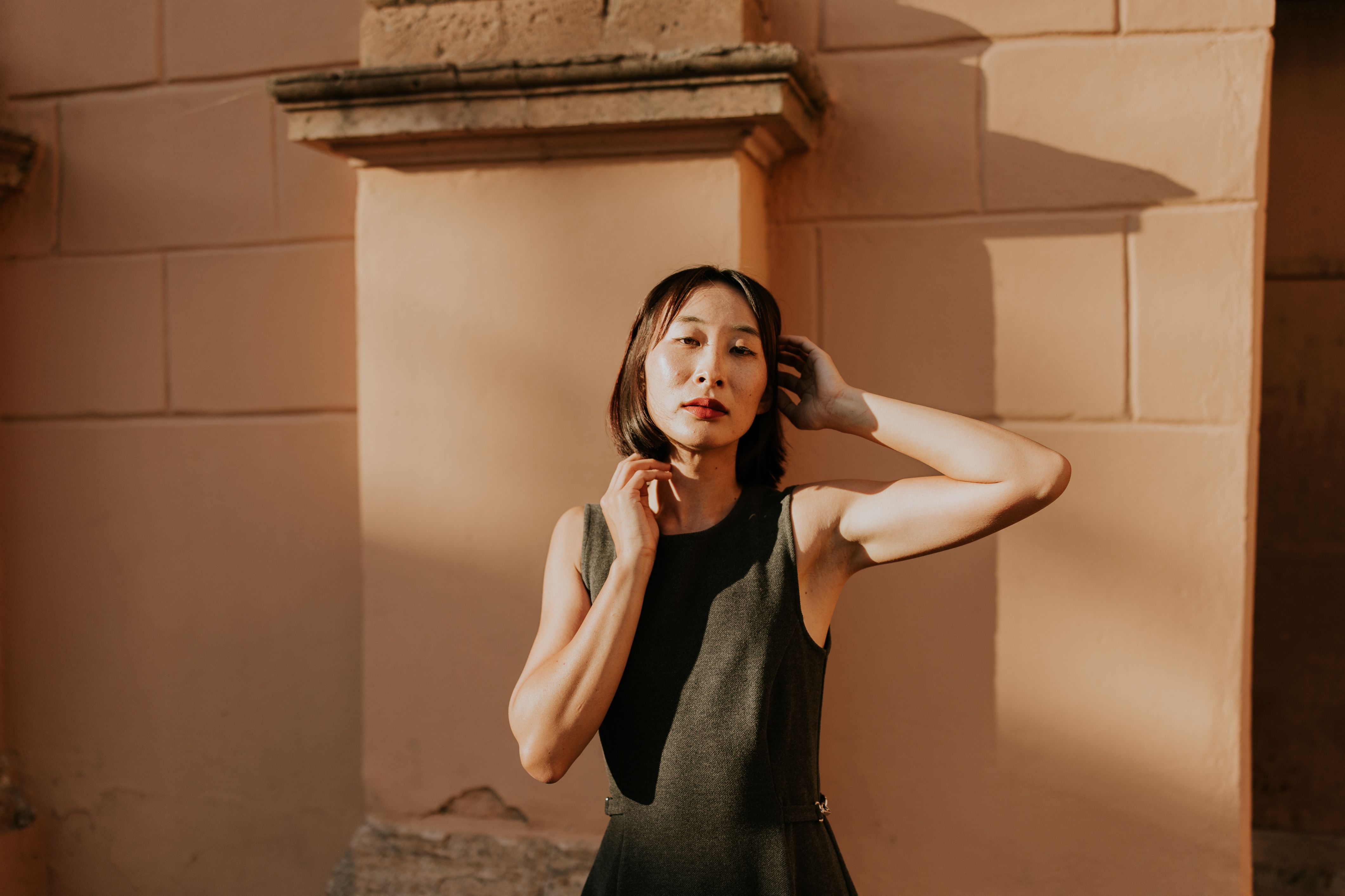 Elegant Woman Posing in Sunlit Urban Setting · Free Stock Photo
