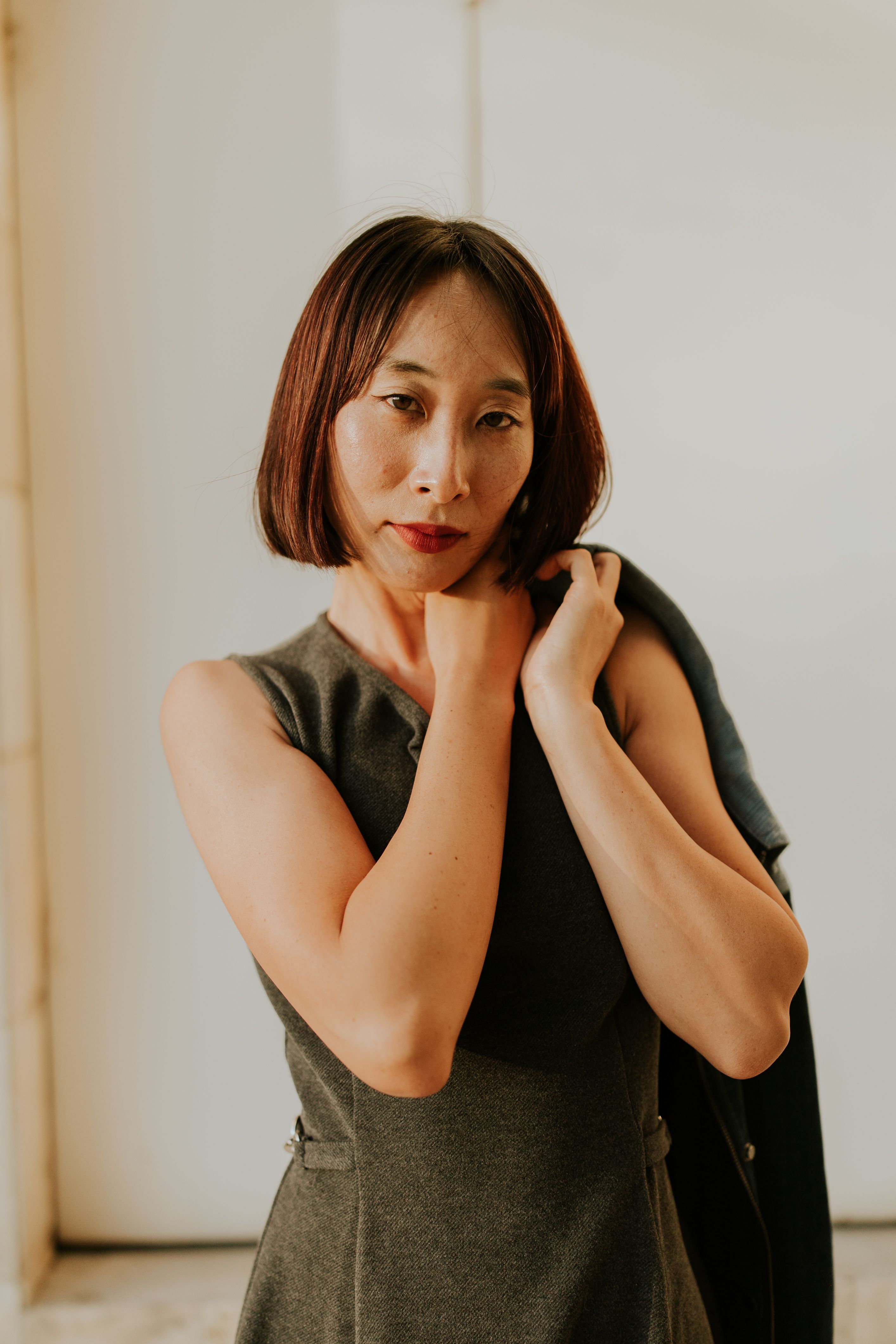 Stylish portrait of a contemplative woman in natural light wearing a dress.