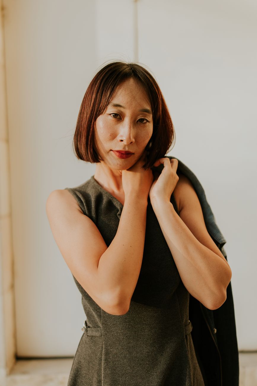 Stylish portrait of a contemplative woman in natural light wearing a dress.