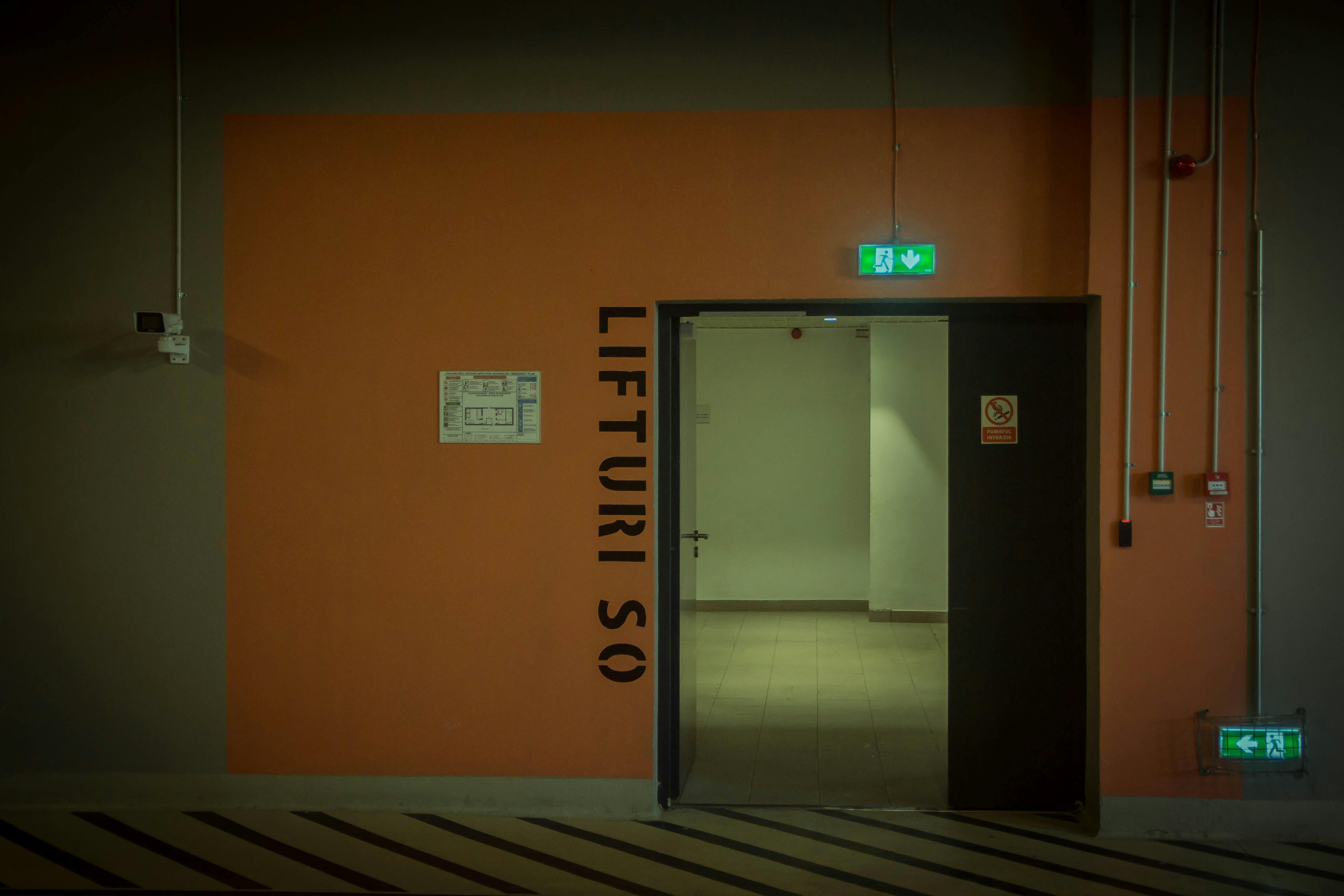 무료 지하 주차장의 열린 출입구로, 눈에 잘 띄는 표지판과 조명이 설치되어 있다. 스톡 사진