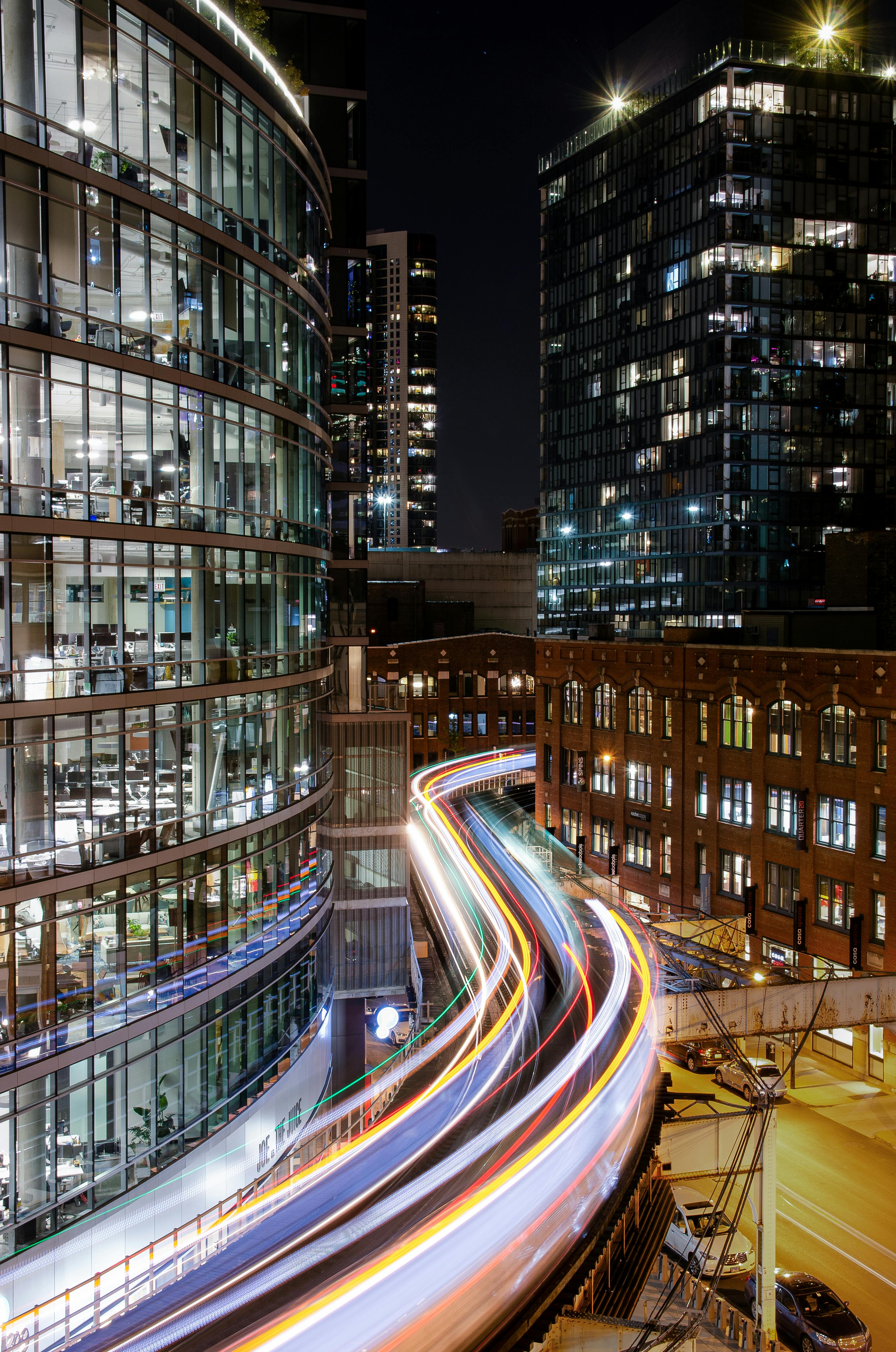 夜间，火车灯光照亮的小径令人惊叹地长时间展现出芝加哥充满活力的城市景观