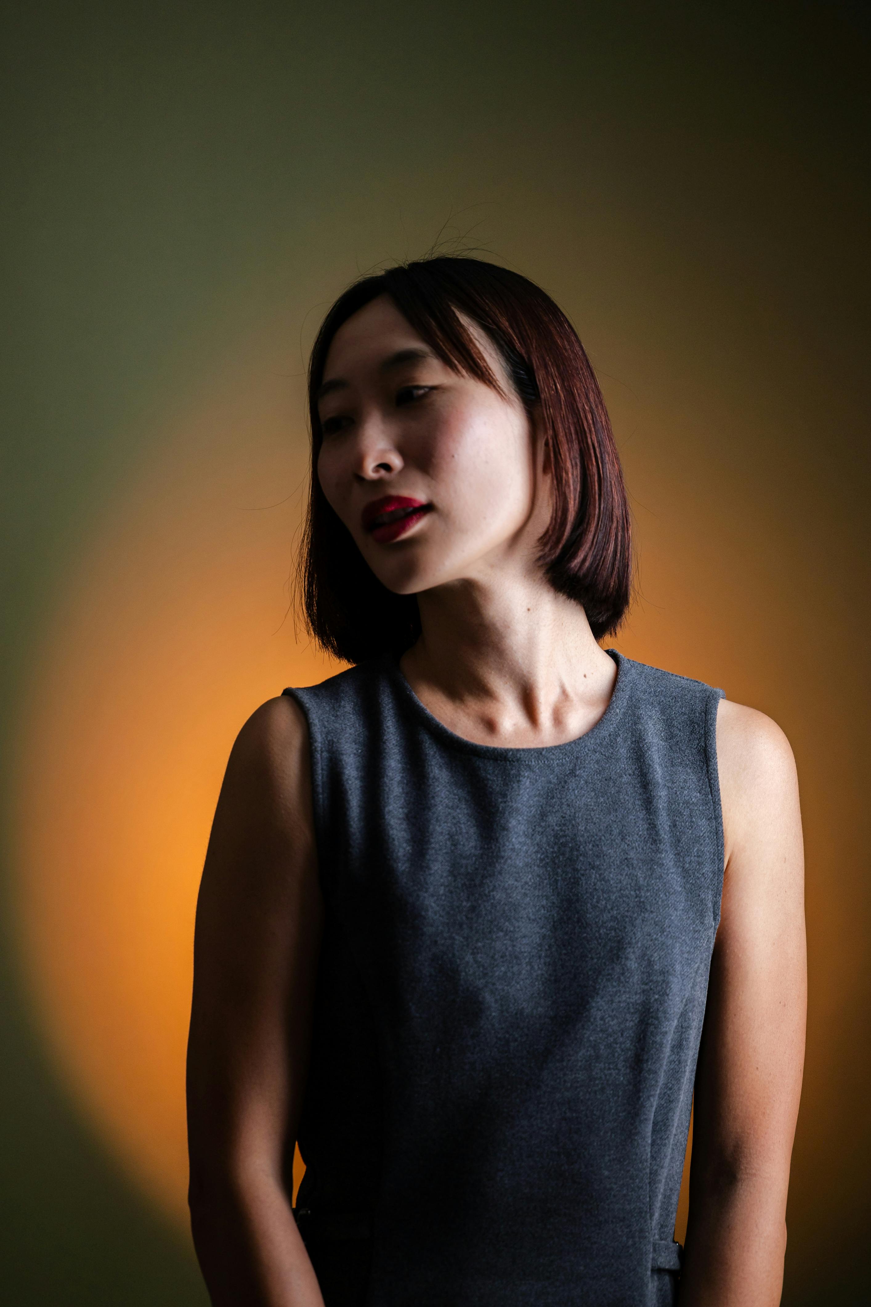 Artistic portrait of a woman with dramatic lighting against a colorful backdrop.