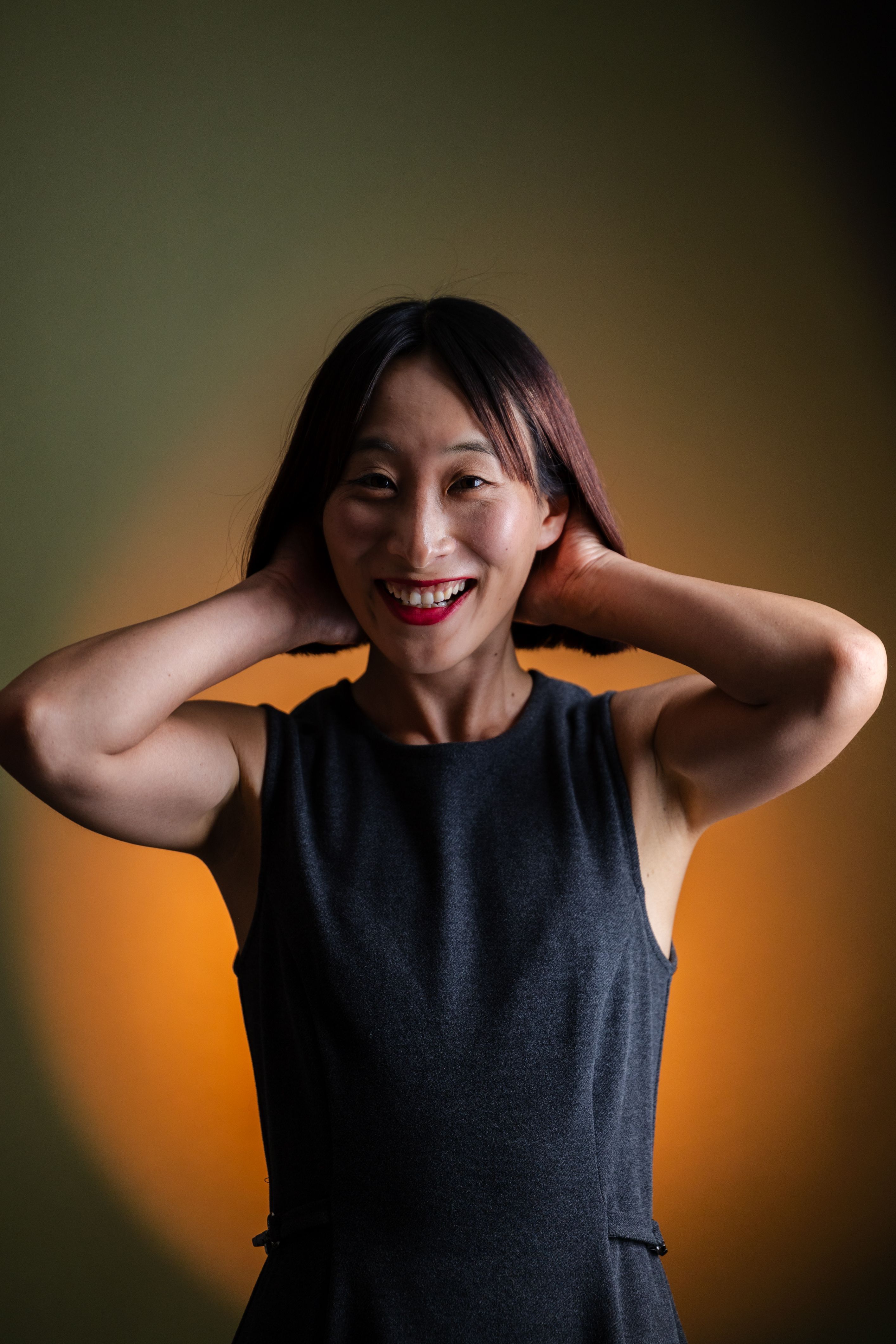 Portrait of a joyful woman with a warm, dramatic background lighting.
