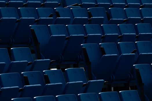Symmetrical rows of empty blue stadium seating showcasing modern architecture.