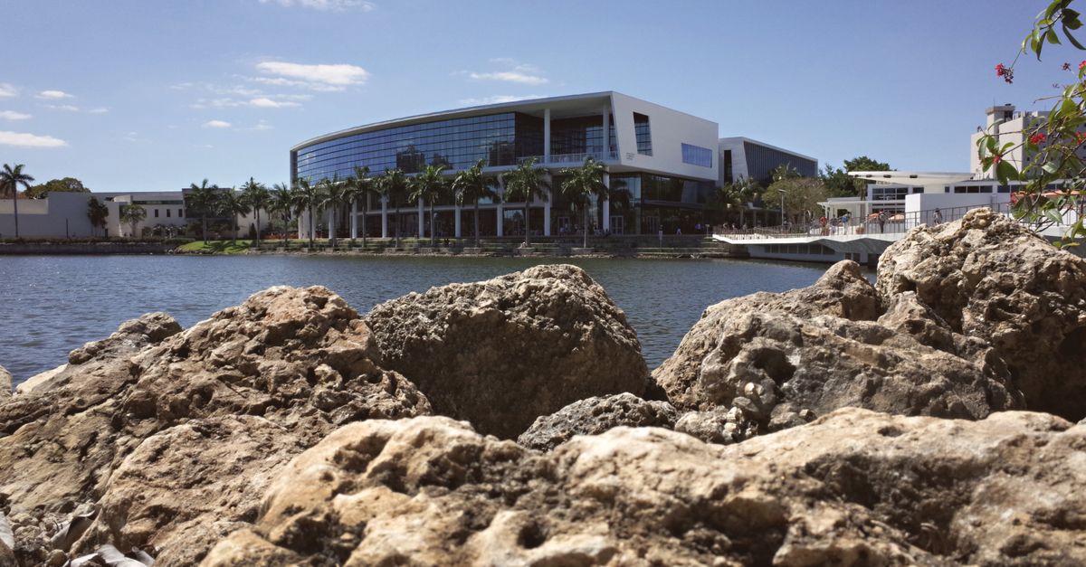 View of a modern university campus in Coral Gables, Florida with waterfront and rocks.