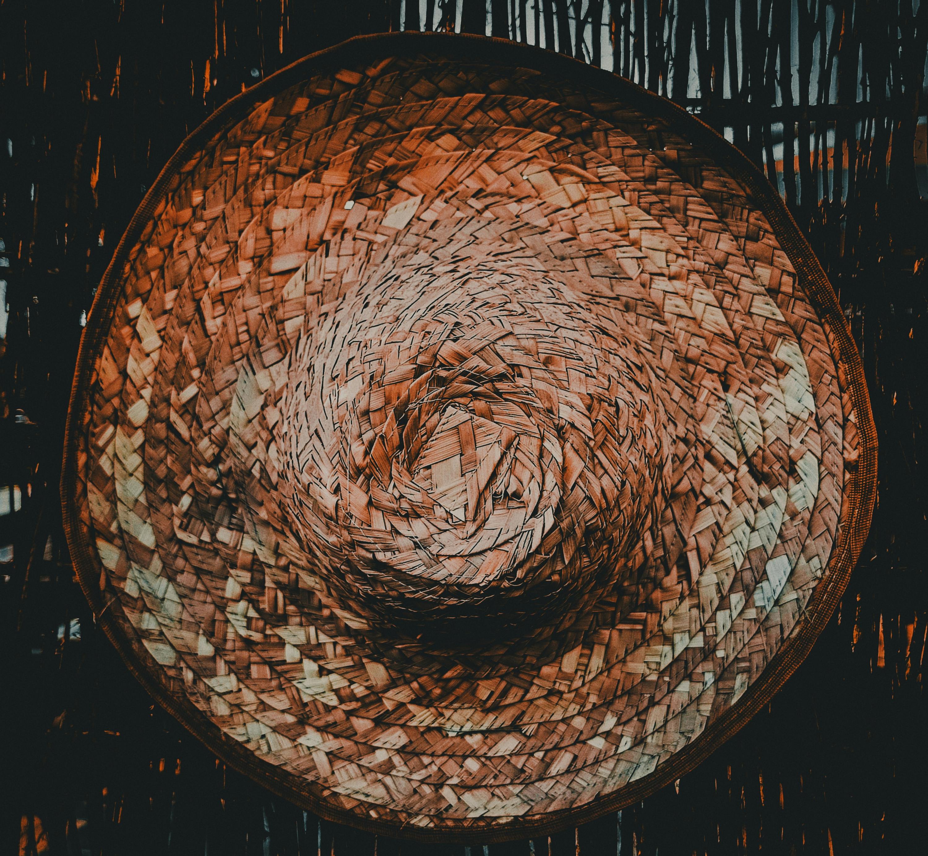 Gratis Fotografia dettagliata di un tradizionale cappello di paglia intrecciata su uno sfondo di legno. Foto a disposizione