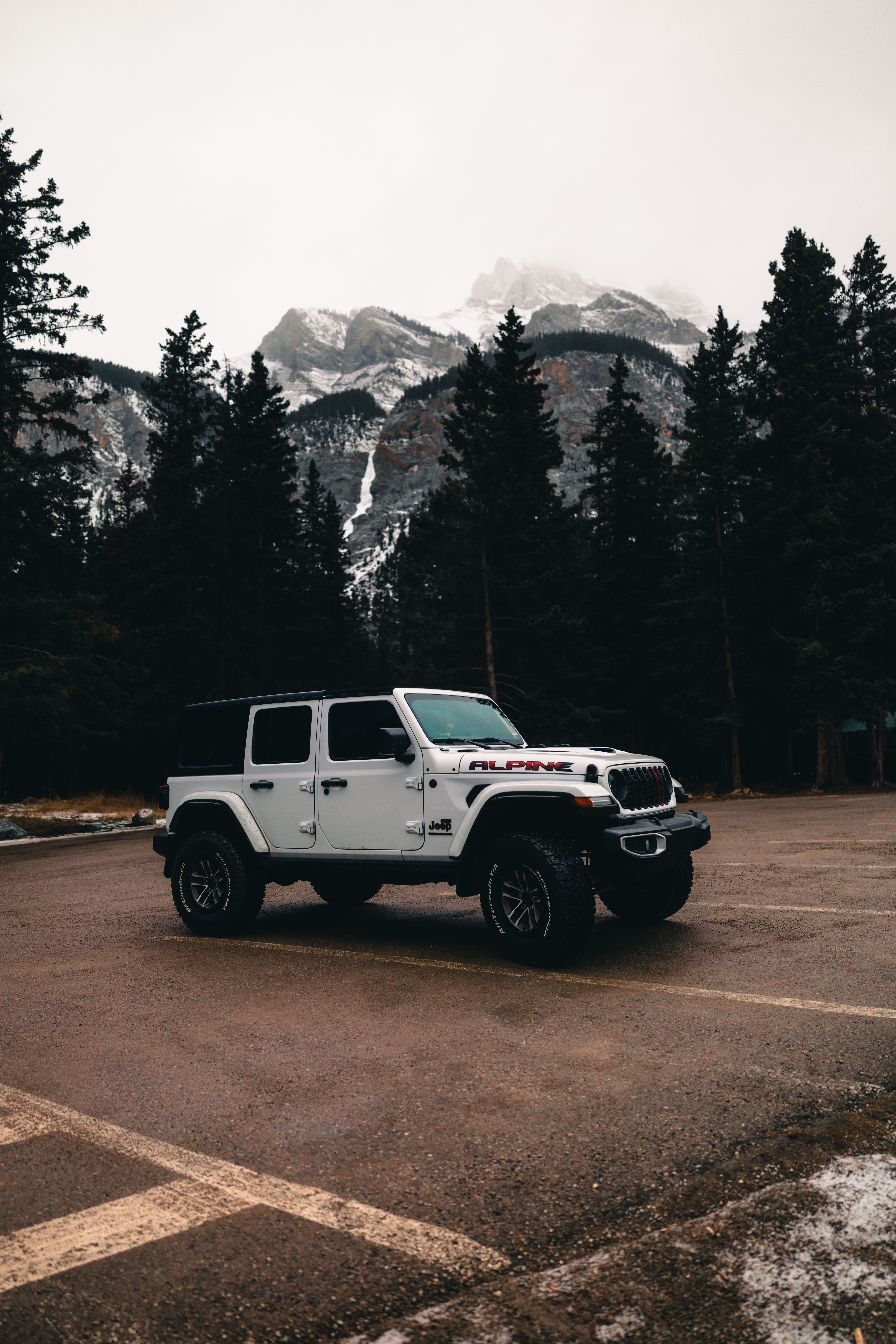 White Jeep against mountain backdrop in Banff National Park, Alberta.