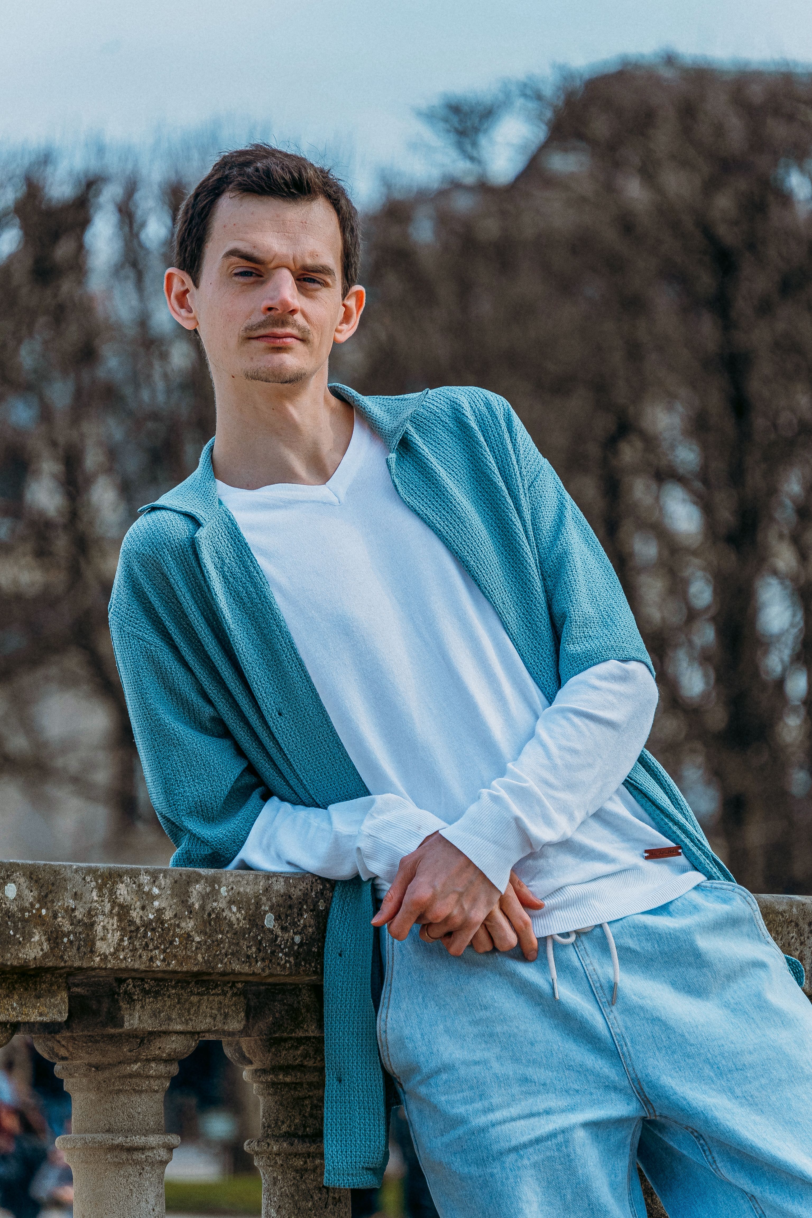 Casual fashion portrait of a man in a park in Paris, France.