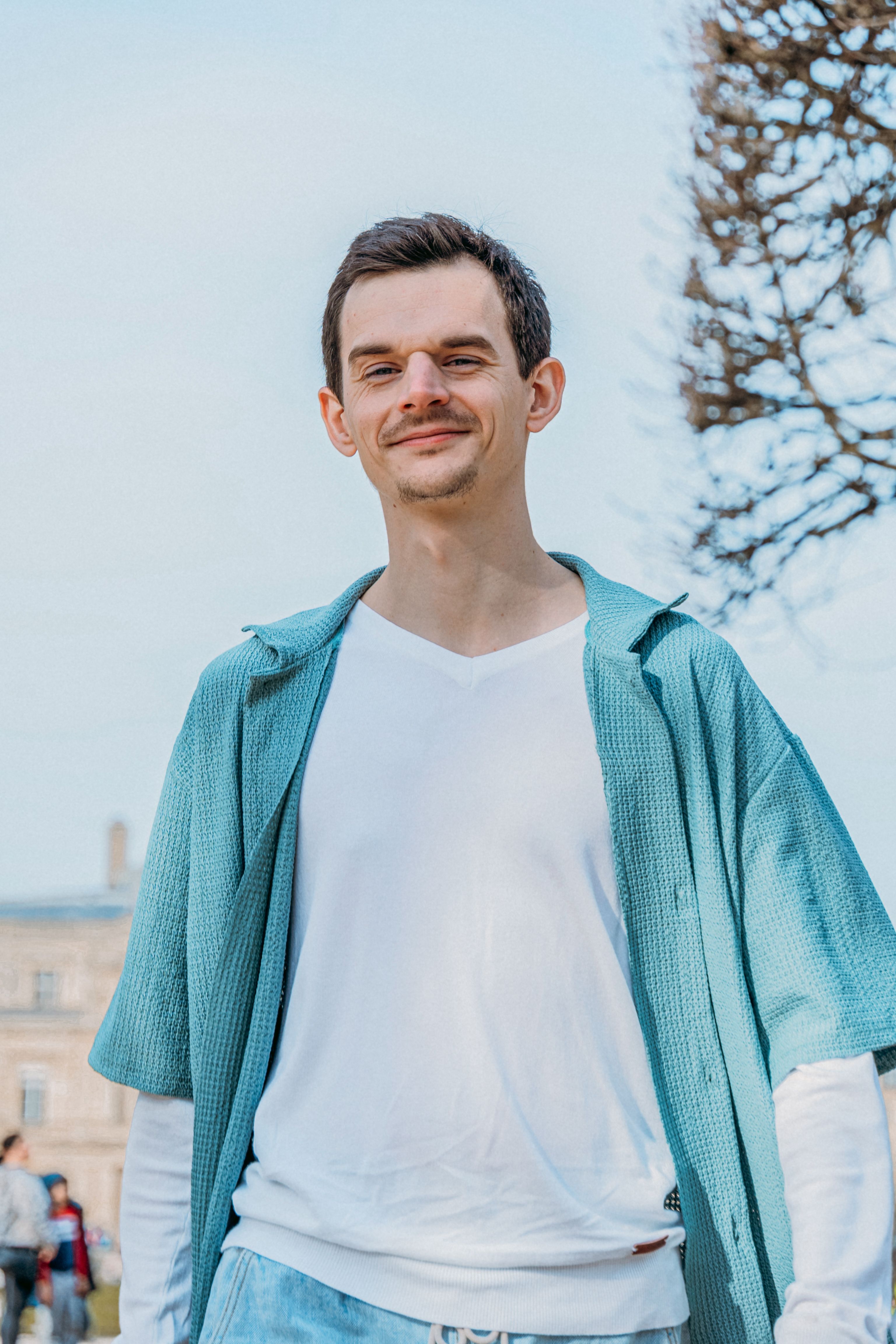Portrait of a man in casual fashion captured in a Paris park.
