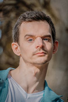 Portrait of a man in trendy street style, captured in Paris, highlighting modern urban fashion.