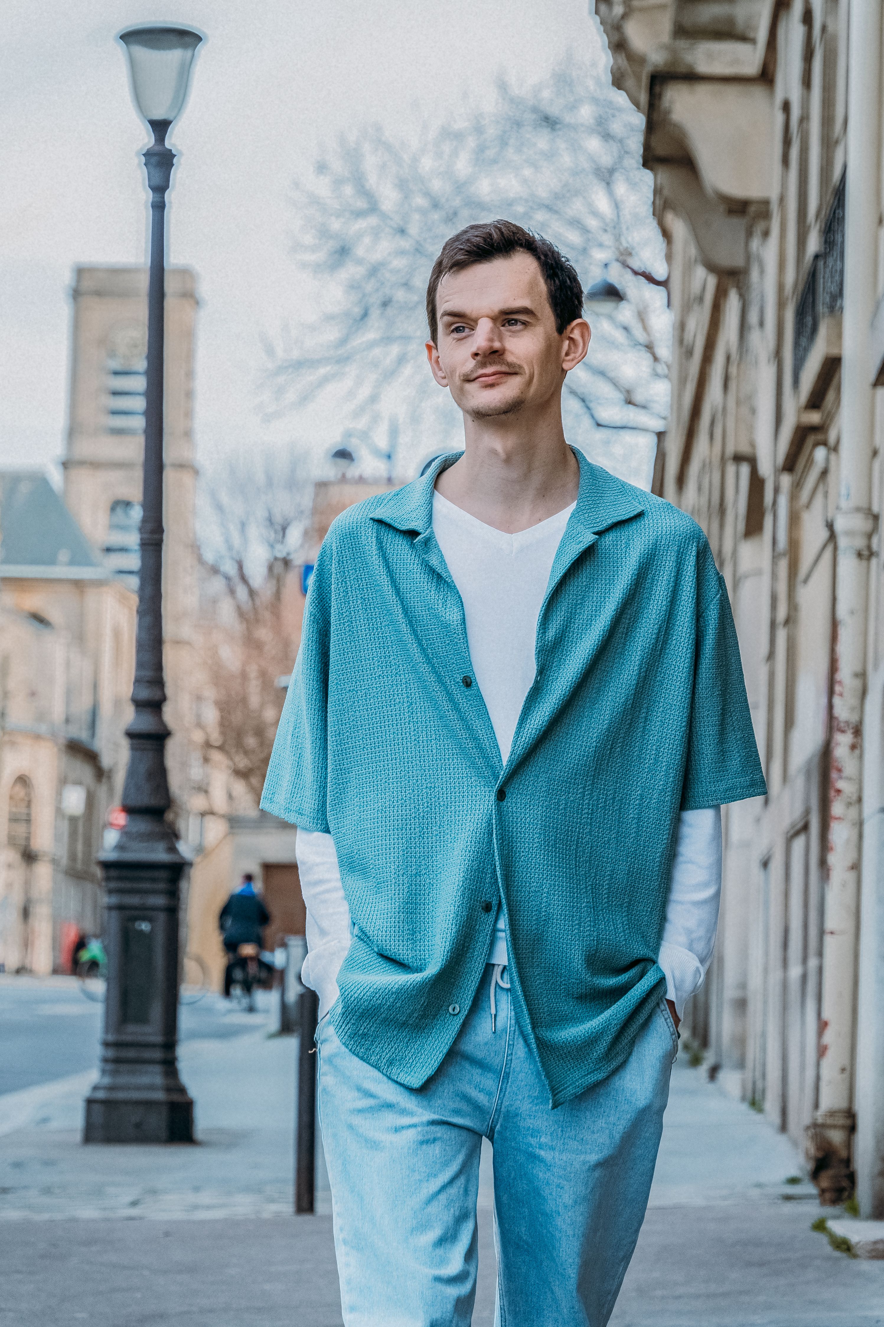 Casual street style portrait of a young man strolling a Paris street.